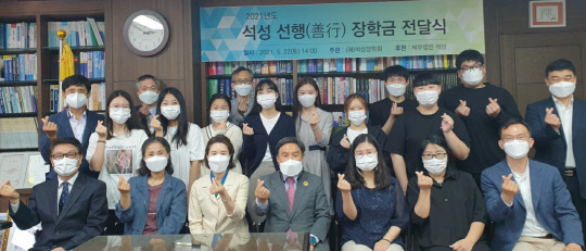 조용근(앞줄 왼쪽 네번째) 석성장학회 이사장이 2021년도 선행 장학생으로 선발된 초·중·고·대학생 180명에게 장학금을 전달하고 수상자와 기념촬영을 하고 있다.   [석성장학회 측 제공]